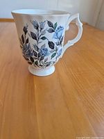 Side view showing blue rose pattern and pedestal foot