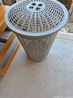 Full view of gray ventilated plastic hamper standing upright