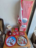 Overview showing boxed Holiday Joy tree, decorative trays, Lenox ornament boxes, NOEL cards, red glass vase