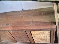 Closed view of wood console stereo cabinet with cane grille