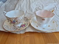 Both teacup and saucer sets side by side on table