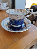 Single teacup on saucer showing cobalt blue and gold gilt design