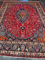 Full view of red Mashhad rug with border and medallion
