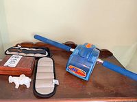 Lot overview showing AB Slide roller, two weights, stone figurine, wooden box