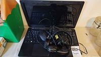 Acer laptop open with Labtec headphones resting on keyboard
