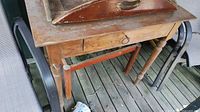 Front view of farmhouse table showing drawer, legs and attached tray