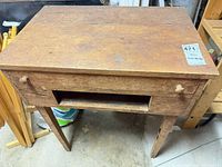 Front view of desk showing empty drawer cavity, knobs, legs, wear