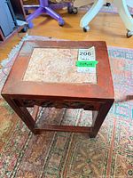 Overall view of the wooden side table with stone top and lot sticker visible