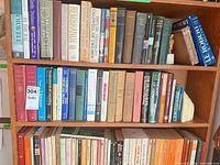 Three shelves filled with assorted hardcover and paperback books