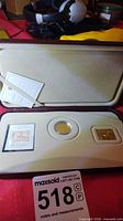 Open presentation case displaying coin, stamp replica, and compartment layout