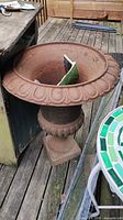 Full view of cast-iron style garden urn on deck