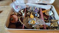 Open case showing assorted cufflinks, tie bars and lapel pins