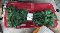 Garland on red bin lid with attached tag and power cord visible