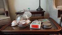 Overall lot on coffee table showing glass pieces, seashell, books, coaster set and tile