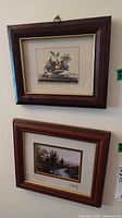 Both framed prints hanging on wall