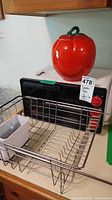 Overview showing DeLonghi toaster oven, red apple cookie jar, metal dish rack and utensil holder