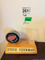 Front view of display showing puck, empty holder, and nameplate