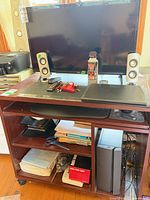 Overall shot showing TV, speakers, Lenovo tower, office cart contents
