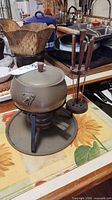 complete fondue set on counter showing pot, lid, stand, burner, fork holder with forks