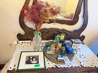 Overall lot showing mirror, vase, print, tray with perfumes, tins