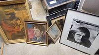 Group shot showing five framed artworks leaning against wall