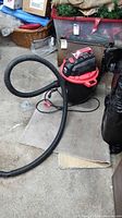 Jobmate wet/dry vacuum with hose attached, power cord visible