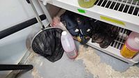All items together near shelving: net, skates, sandals, fluid