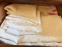 Stack of white linens folded in drawer