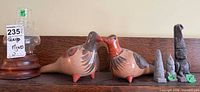 Group shot of hurricane lamp, two ceramic birds, five tiki figurines