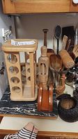Group view of utensils inside glass holder, wooden rack, napkin holder, coconut bowl