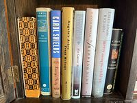 Row of nine hardcover books showing titles and authors