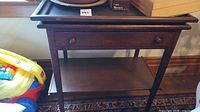 Front view of end table showing top, drawer, lower shelf