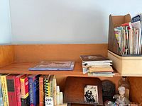 Shelf with assorted books, onyx bookends, wood stand, cast-iron bookend and fabric doll