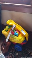 Lot overview with ukulele resting on yellow ride-on filled with blocks