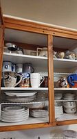 Cabinet view showing mugs, plates, bowls