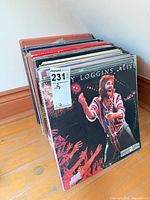 Stack of vinyl records, front album Kenny Loggins Alive