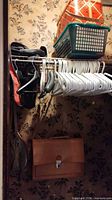 Closet view showing briefcase, umbrella, hangers, handbag