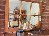 Front view of all items on tabletop with mirror, ship, magnifier, pen set, shell, stone