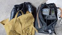 Canvas backpack, black duffle bag, and open bag showing cassette stereo unit inside