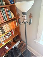 Full view of floor lamp next to bookcase