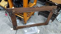 Full view of oak frame with absent mirror and attached hooks/sconces