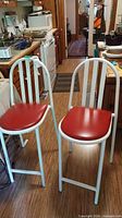 pair of white metal bar stools with red vinyl seats in kitchen setting