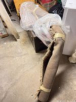 Rolled rug showing full length and frayed edge