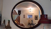 Front view of round wood frame mirror on wall
