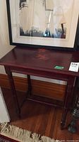 Full view of mahogany side table under framed artwork