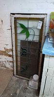 Full view of stained glass panel leaning against wall
