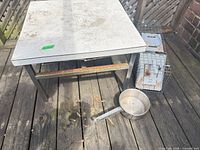 Square stainless-top table, cage, saucepan on deck