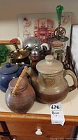 Overview showing teapots, ceramic jar, egg beater, candlestick, pepper mills, chrome dome, crock
