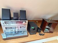 Full view of stacked stereo components, speakers, subwoofer, headphones and CD rack