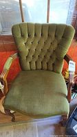 Front view of olive green tufted armchair